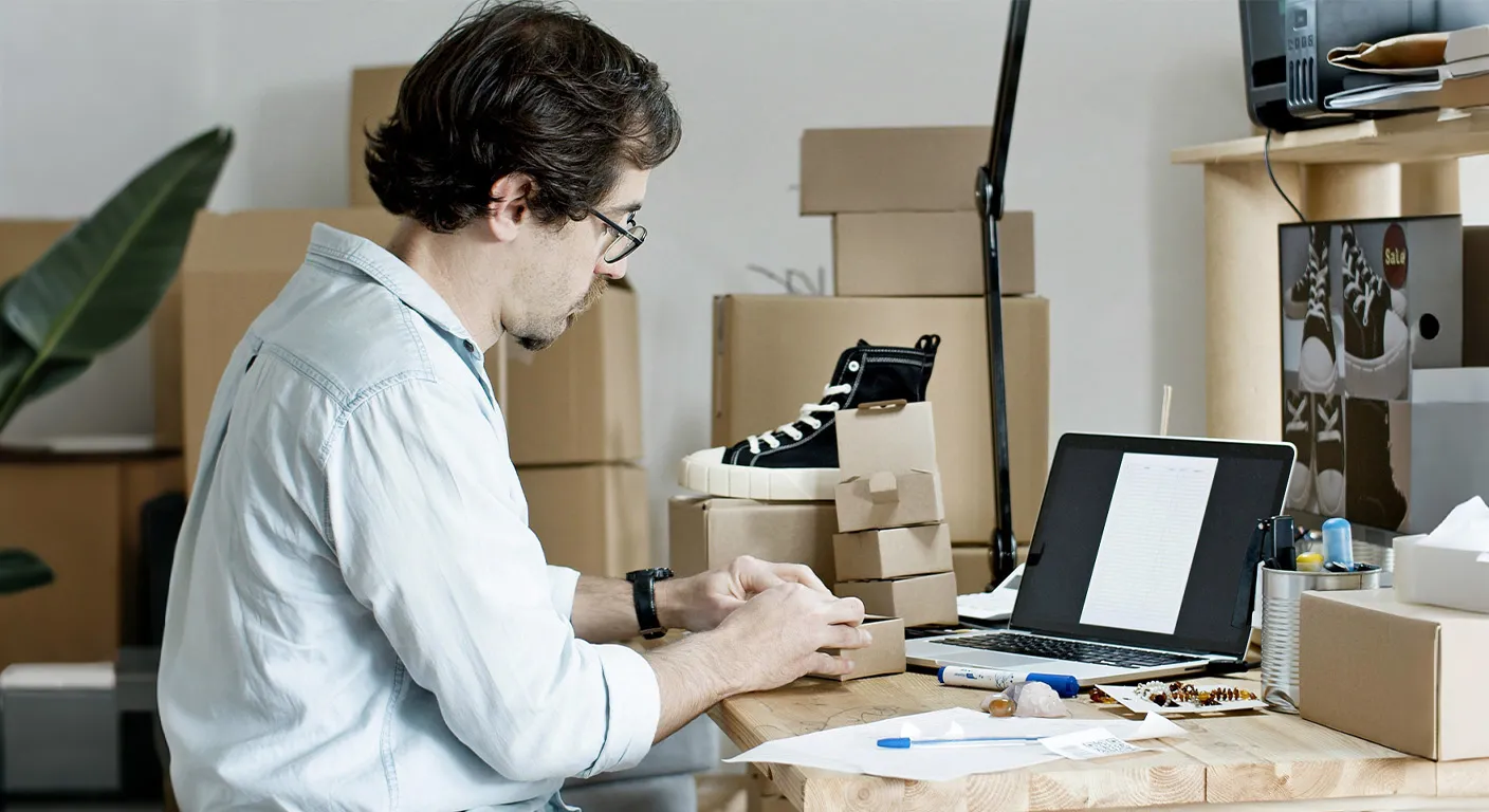 ecommerce entrepreneur building a branded business with product packaging and laptop workspace