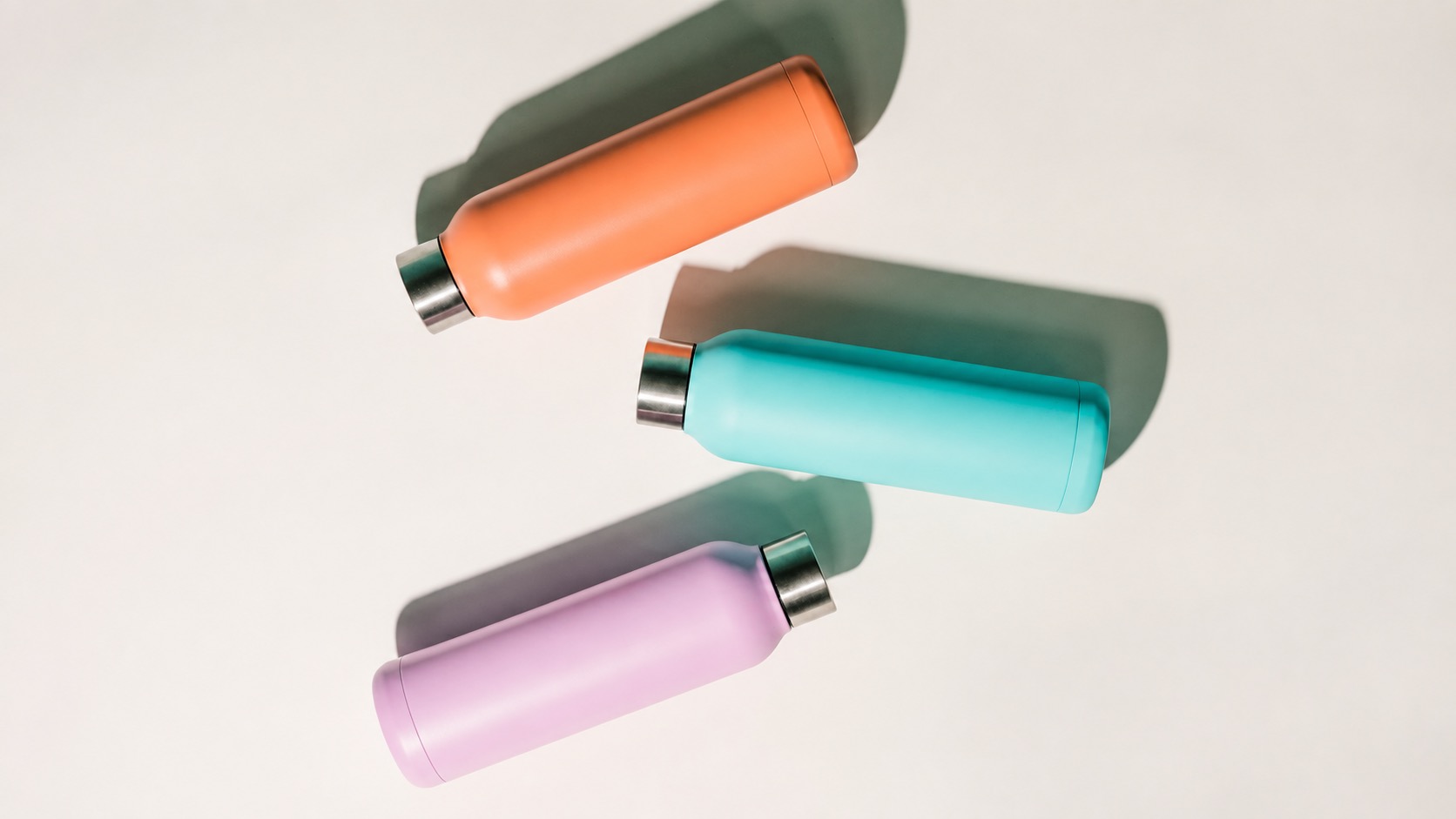 Three capped metal bottles illustrating the assembly behind a leakproof bottle claim