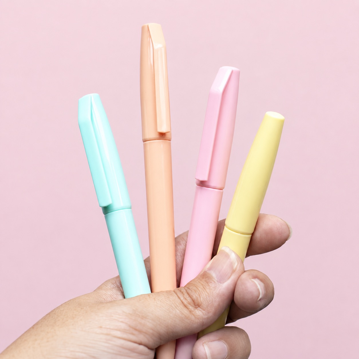Hand holding four different pastel pens, illustrating exact bundle inventory components