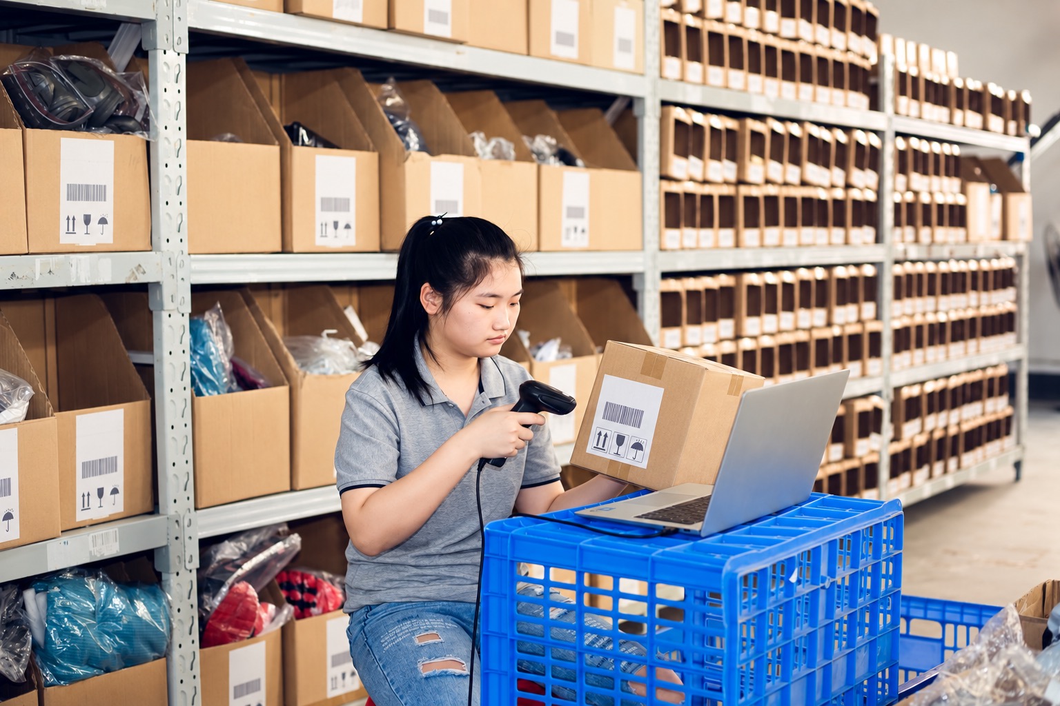 Warehouse worker scanning a carton label with a barcode and handling marks