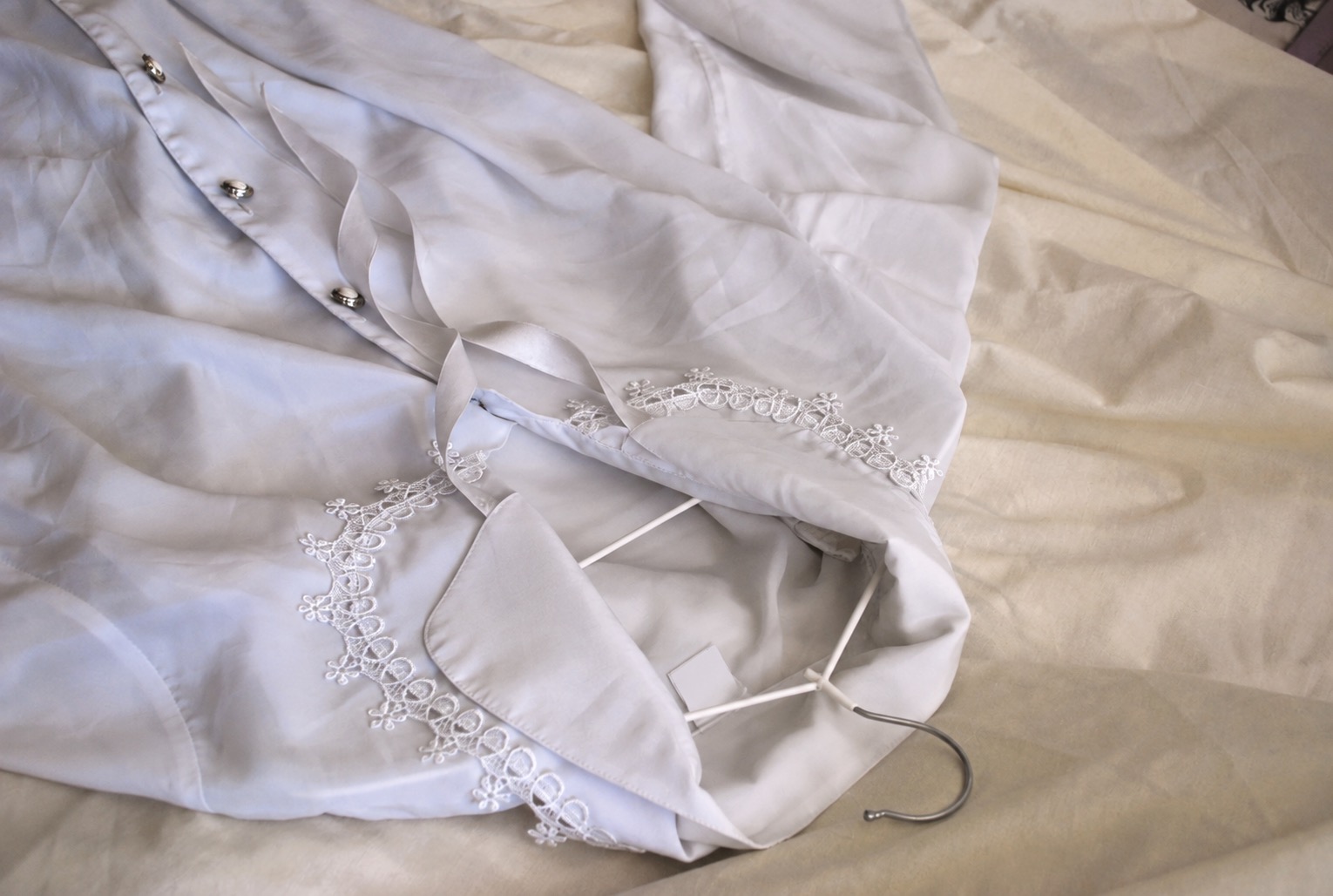 Lace-trimmed blouse with folds and hanger before taking garment measurements
