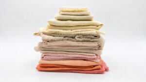 Stacked pale and peach textiles illustrating material-specific supplier color variation