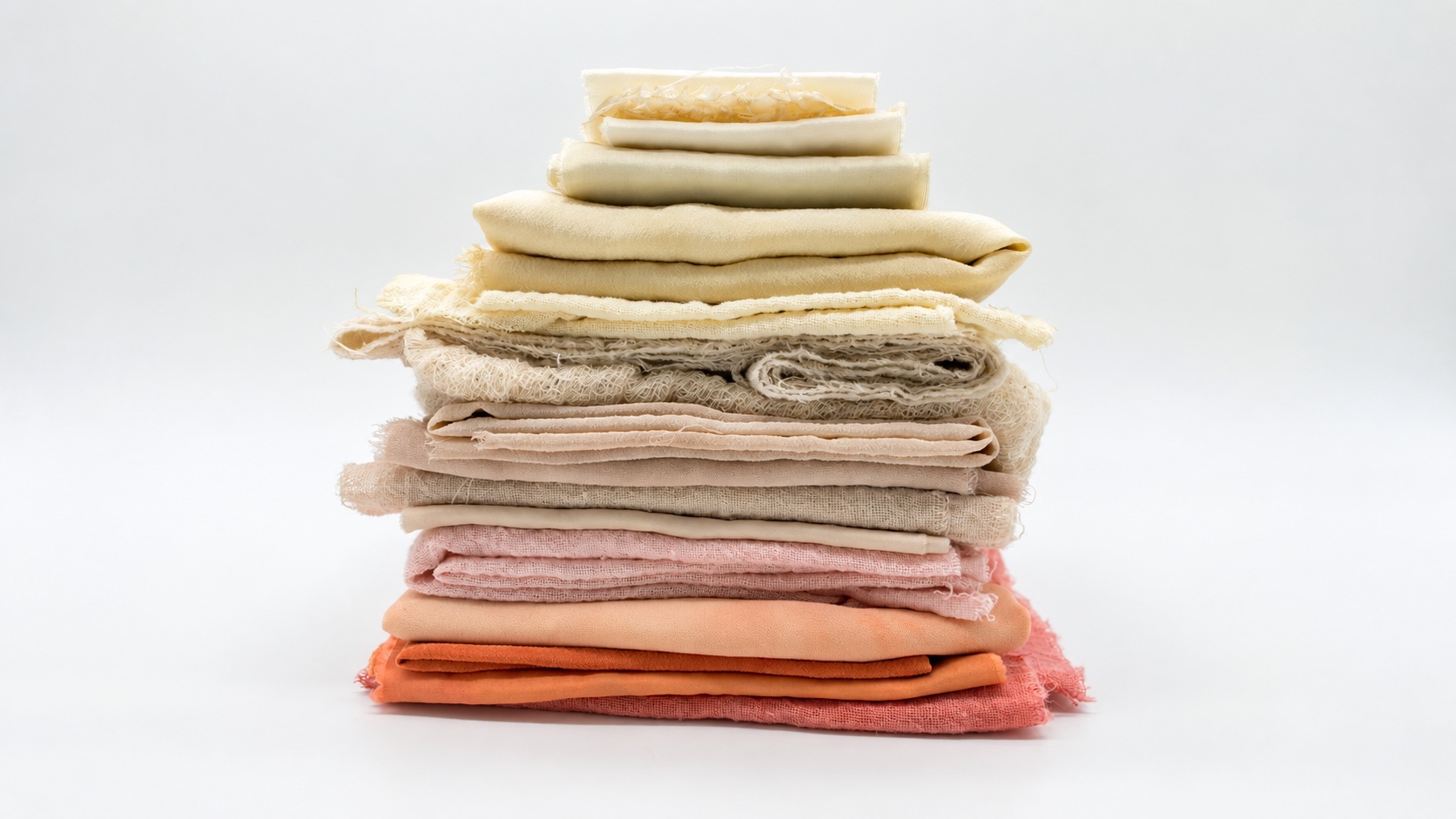 Stacked pale and peach textiles illustrating material-specific supplier color variation