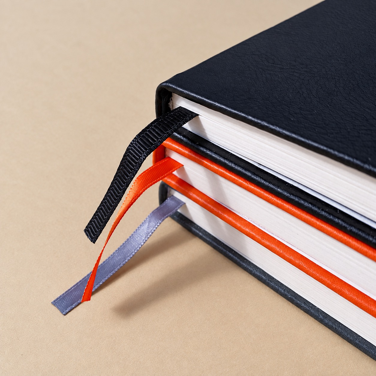 Three notebooks showing cover, page block, binding and ribbon details to compare in quotations