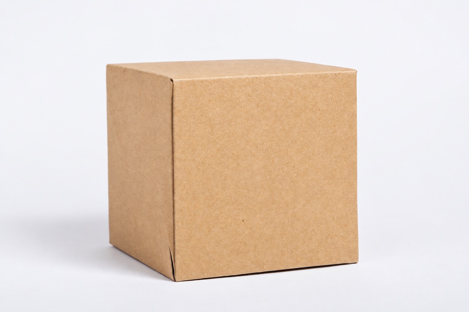 Closed plain kraft carton with visible panel seams and folds on a light surface
