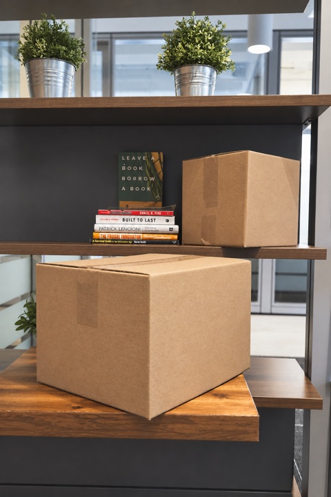 Two closed cardboard boxes resting on separate wooden shelves