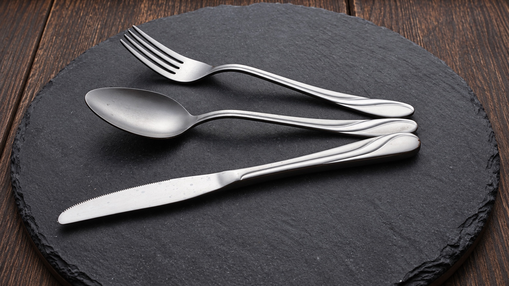 Silver fork, spoon and knife with bright edge highlights for reflective product photography