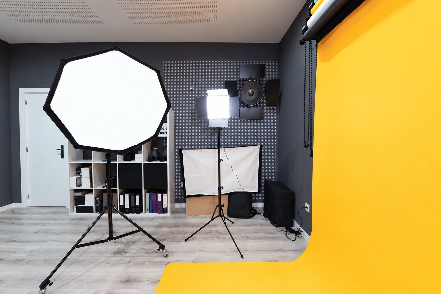 Large octagonal softbox and panel light beside a yellow studio backdrop