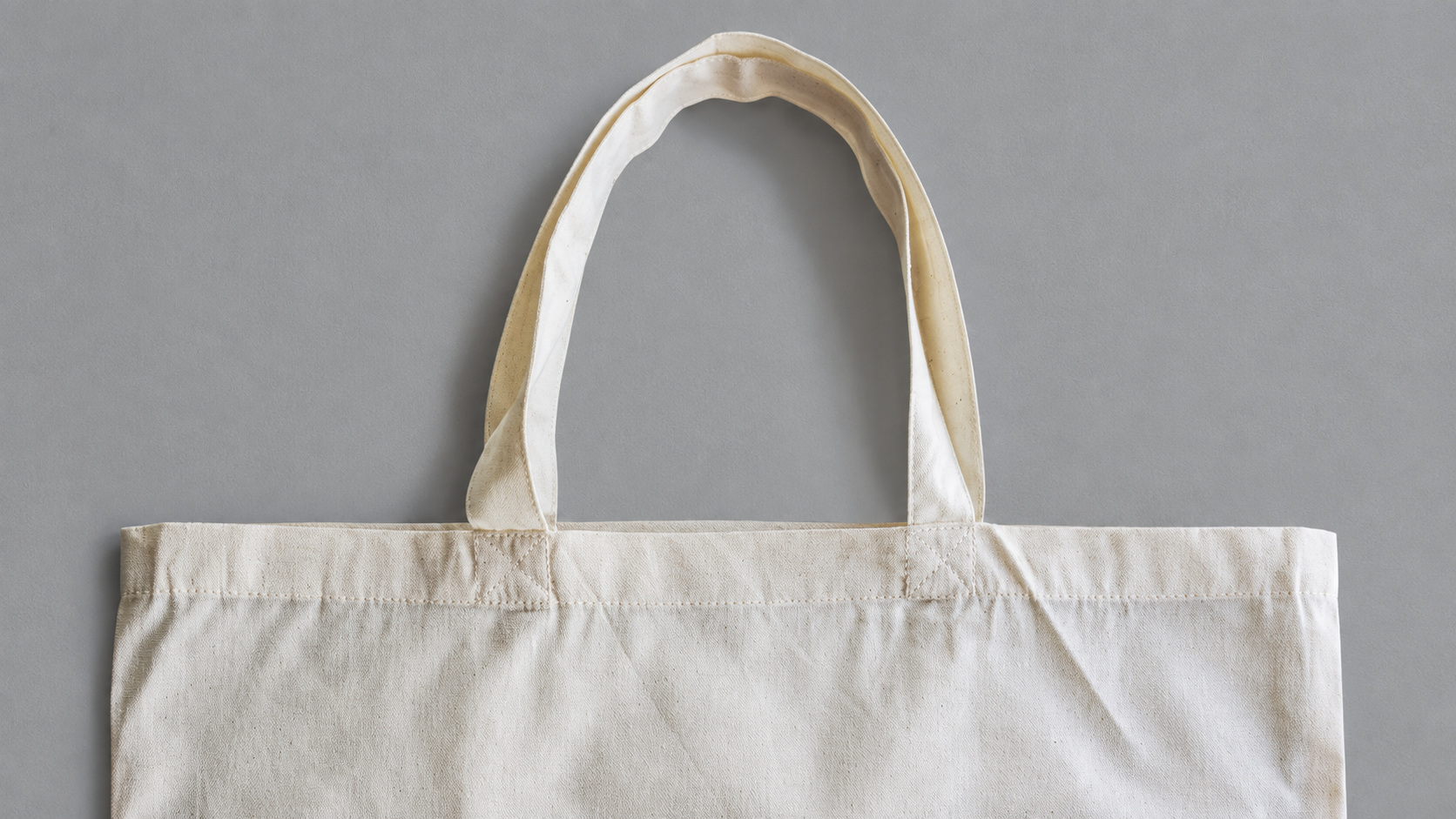 Handle attachments and upper hem in cream tote bag fabric
