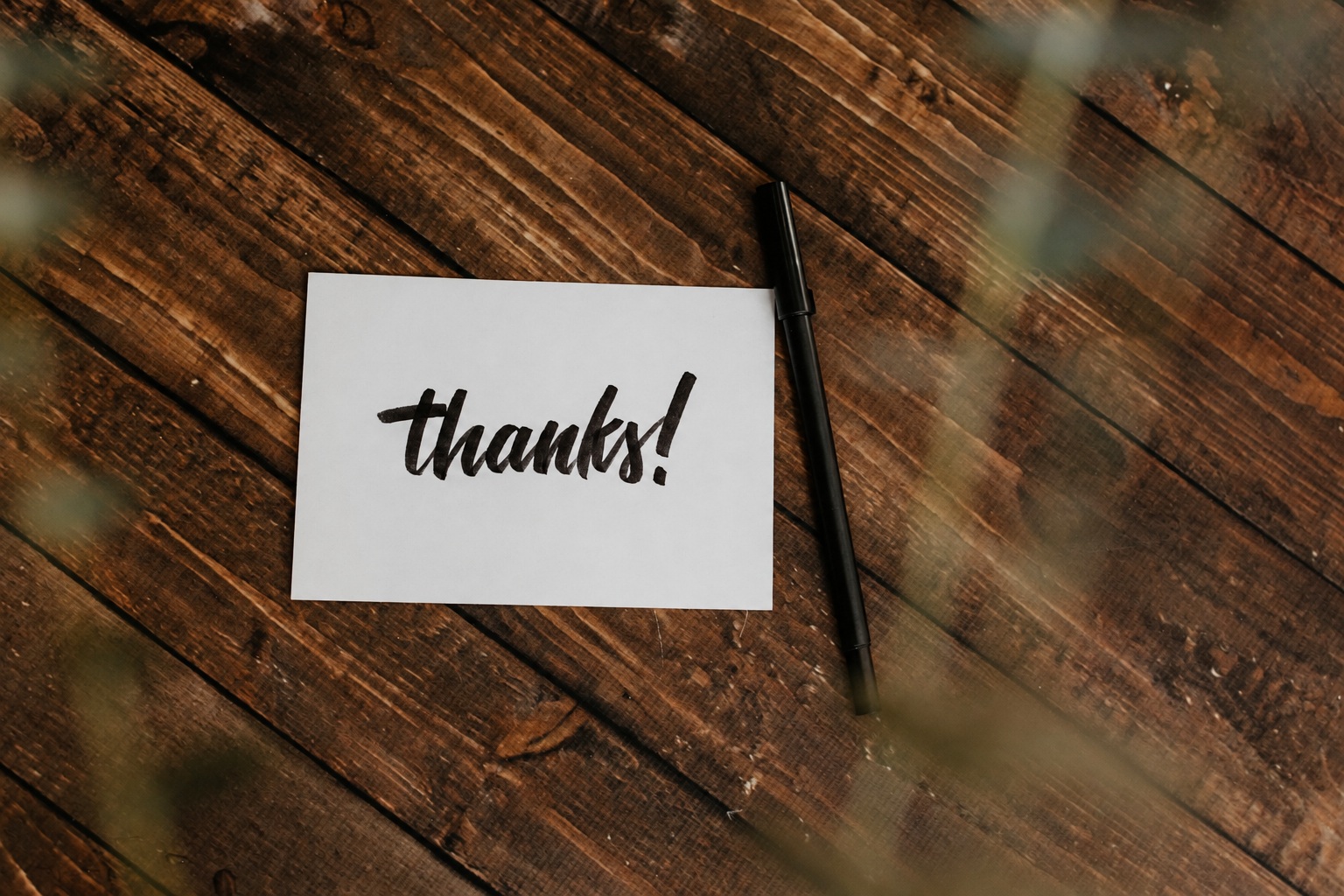 Separate thanks card beside a black pen