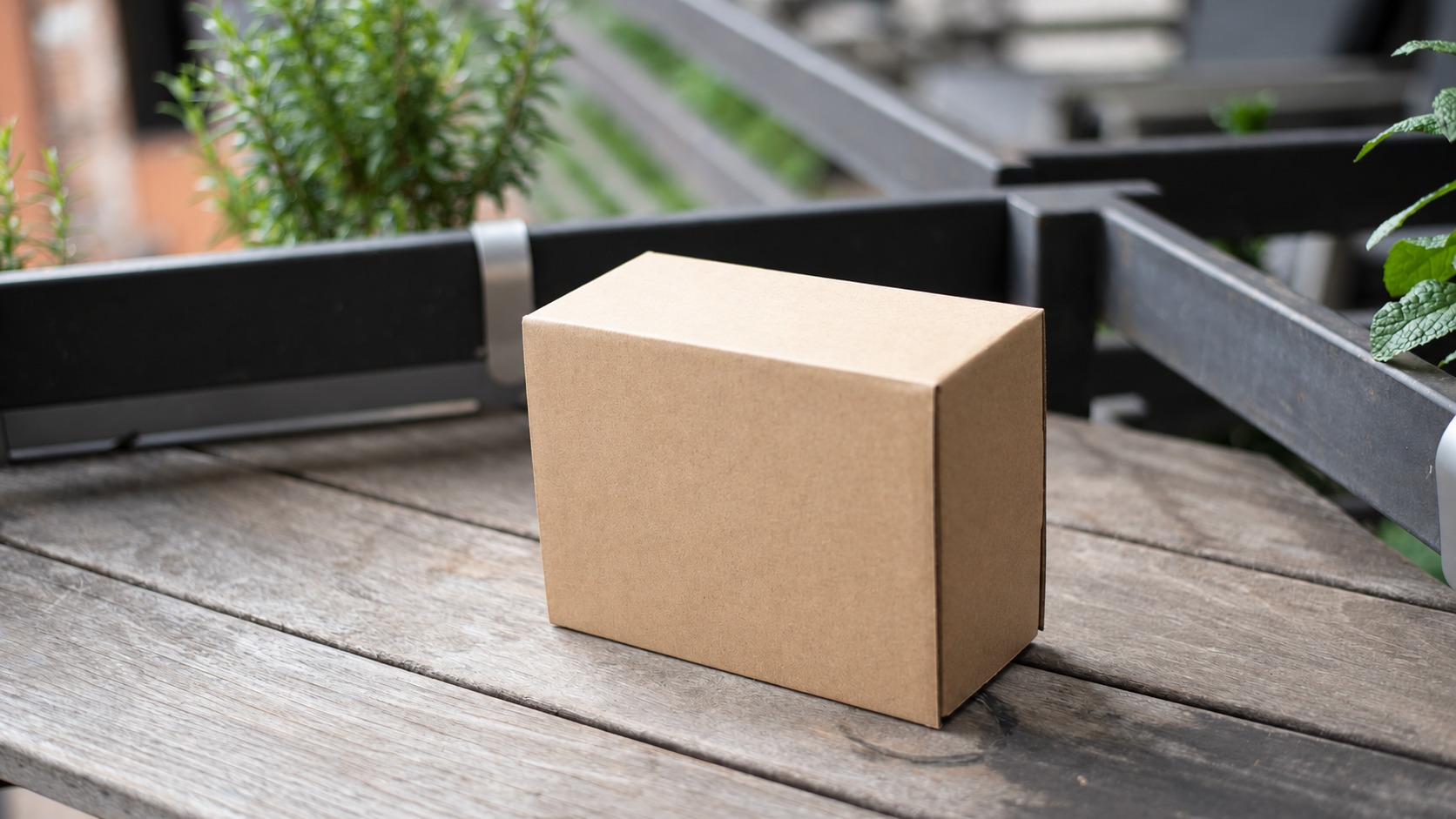 Closed plain kraft box on a wooden table with contents out of view