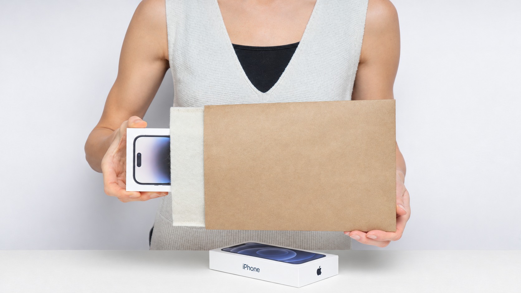 Hands holding a lined protective envelope with a retail box partly inside
