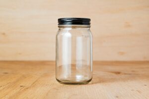 Glass jar with black lid illustrating a complete product and its replacement parts