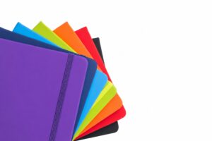 Fanned colored notebooks illustrating variant requirements for a purchasing agent
