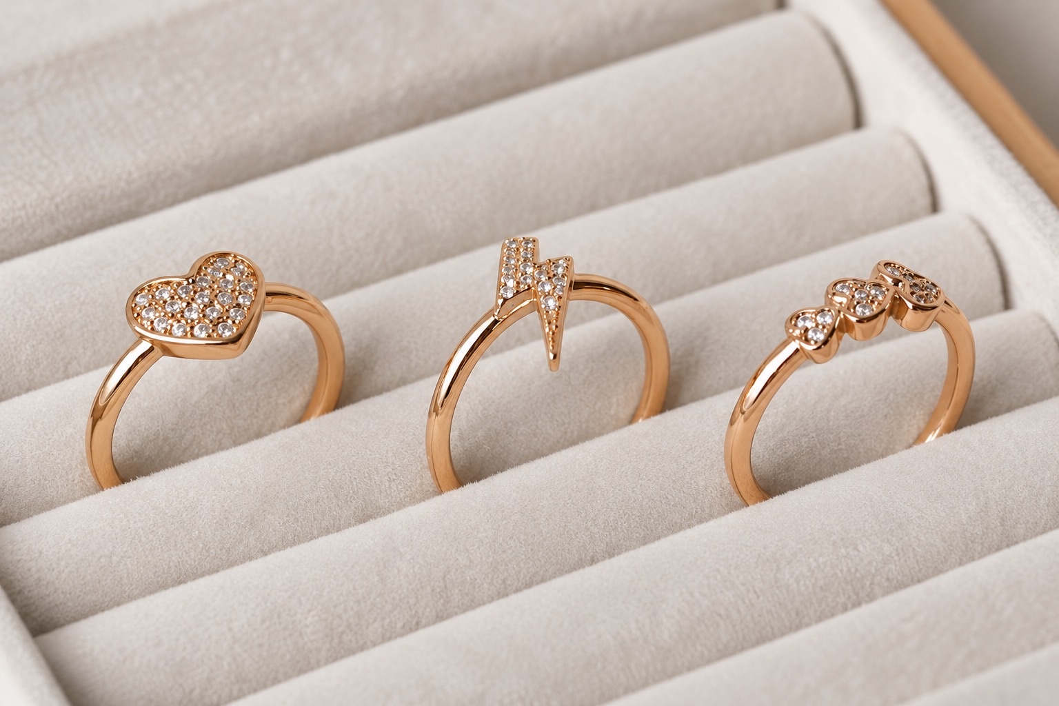 Three rose-gold-colored rings showing visible settings and surface appearance