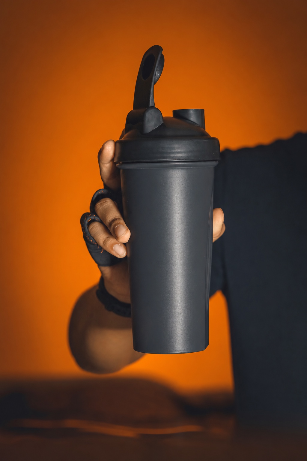 Hand holding a black shaker bottle illustrating direct experience of a physical sample