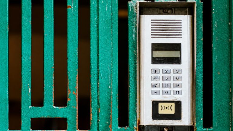 Intercom beside a closed gate illustrating an access obstacle for an undeliverable parcel