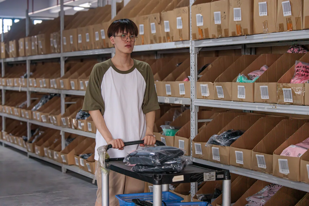 A warehouse trolley beside rows of individually organized product bins