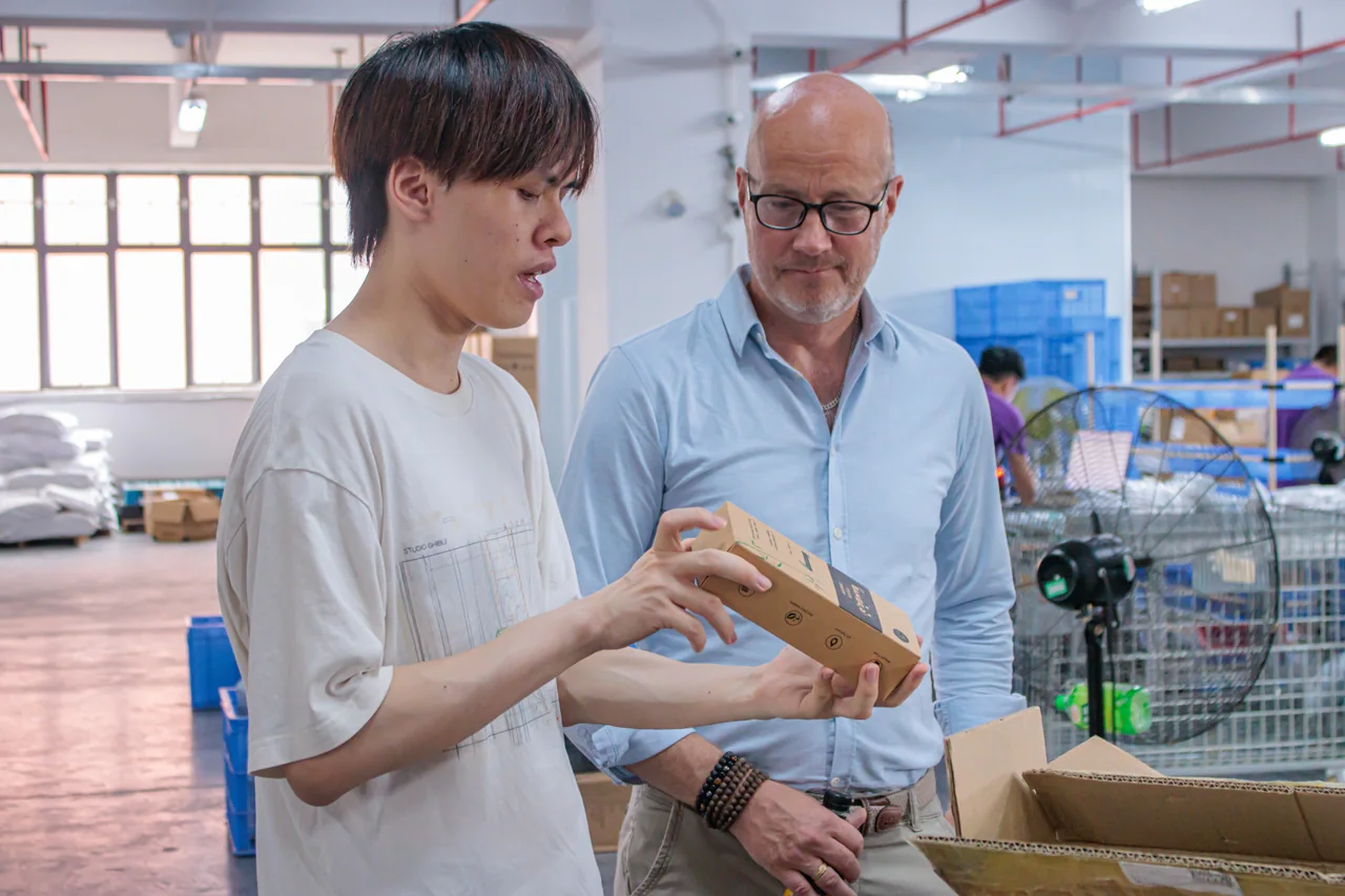 Two people reviewing a small cardboard product package