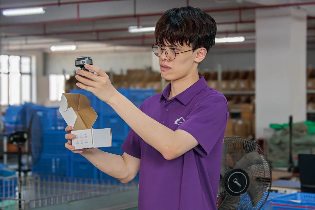 Warehouse team member examining an electric shaver beside its open product box