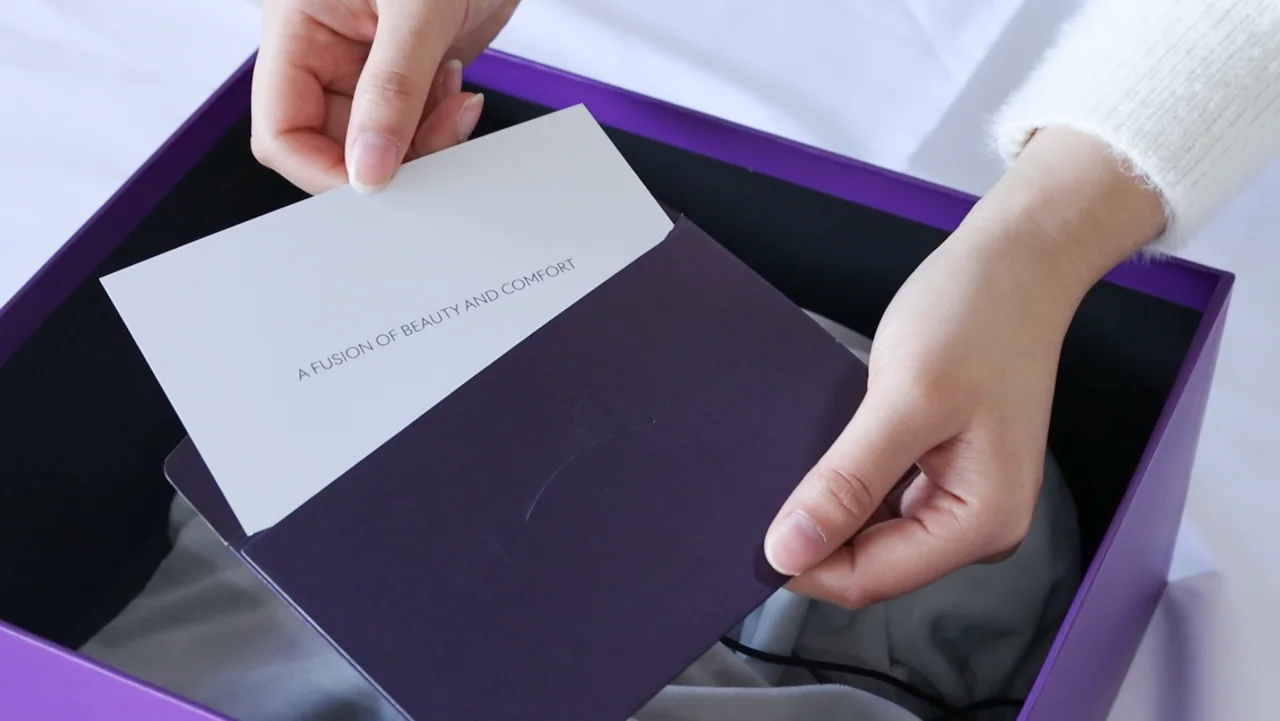 Hands placing a printed insert into a purple presentation box
