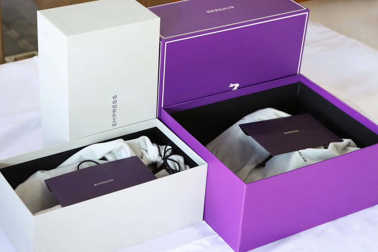 Open presentation boxes with fabric pouches and printed inserts arranged together