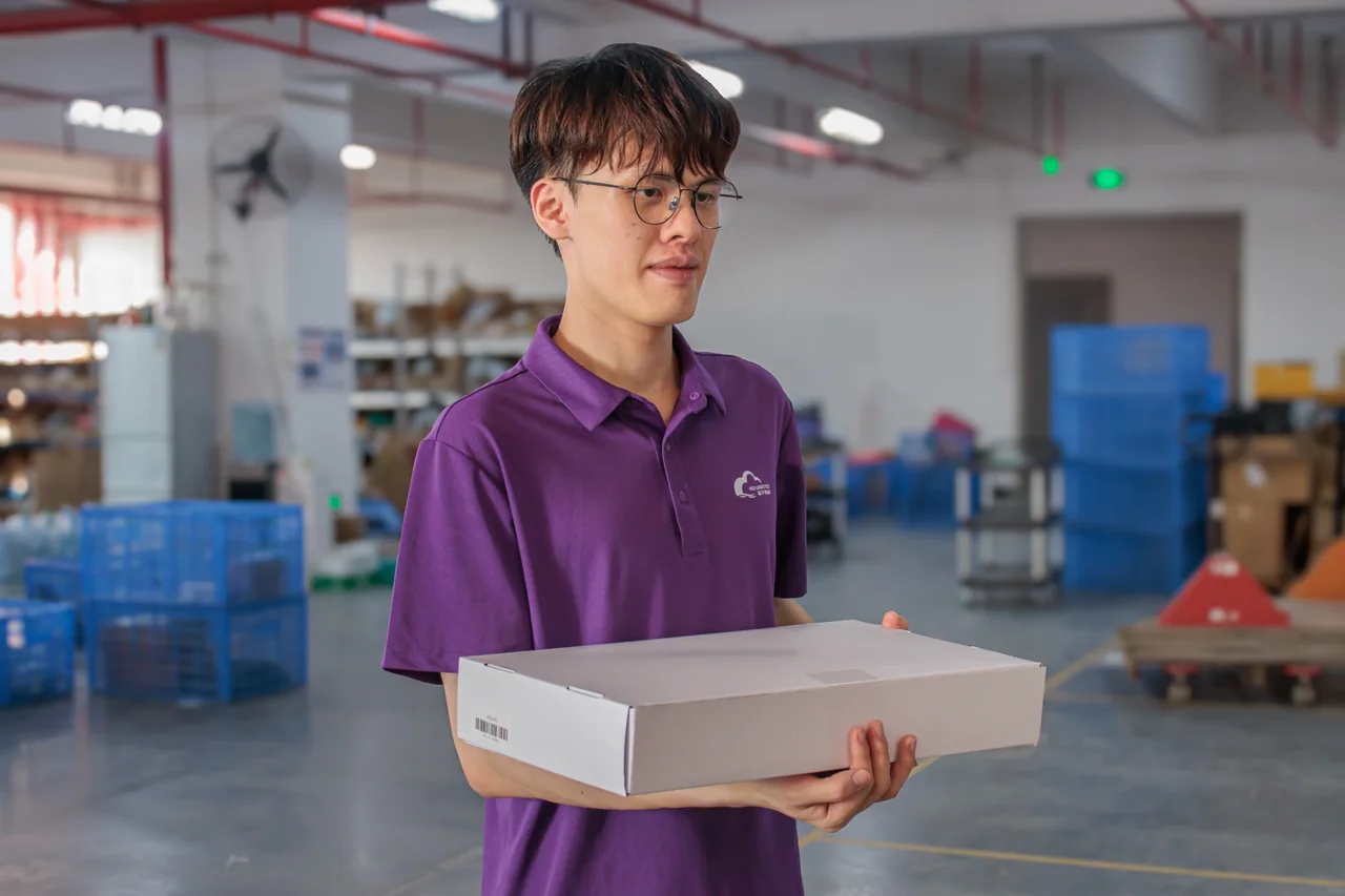 Warehouse team member holding a white folded mailer box