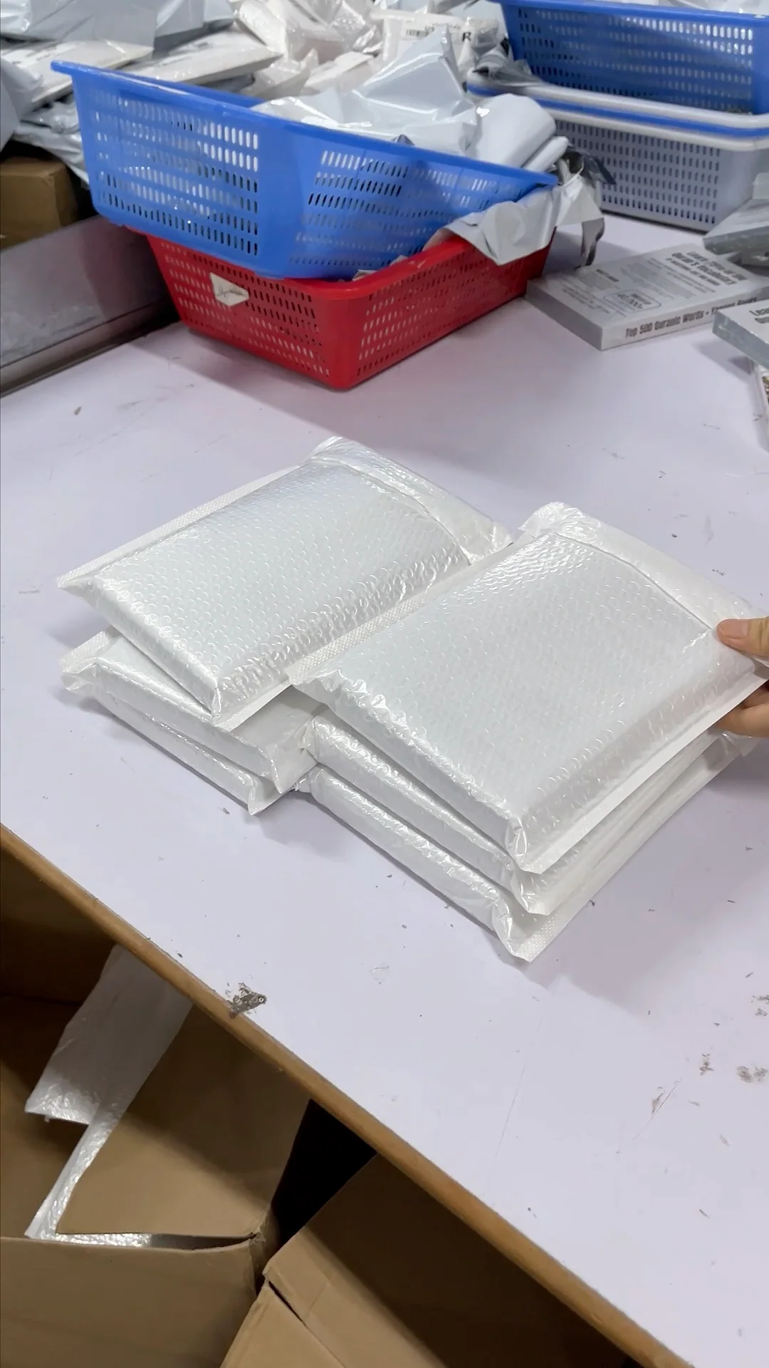White bubble sleeves enclosing products at a warehouse packing table